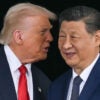 Donald Trump speaks into the ear of a smiling Xi Jinping.