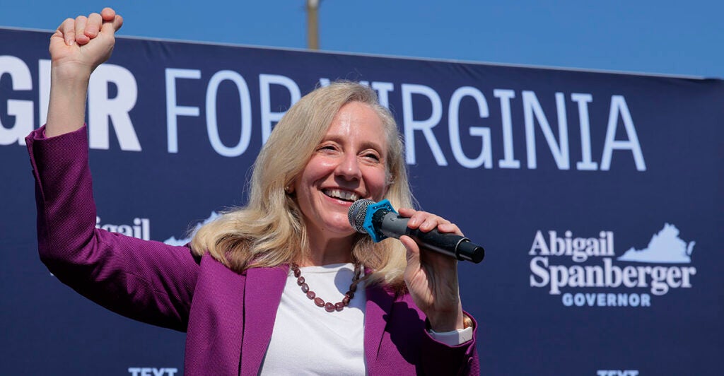 Abigail Spanberger in purple raises her fist