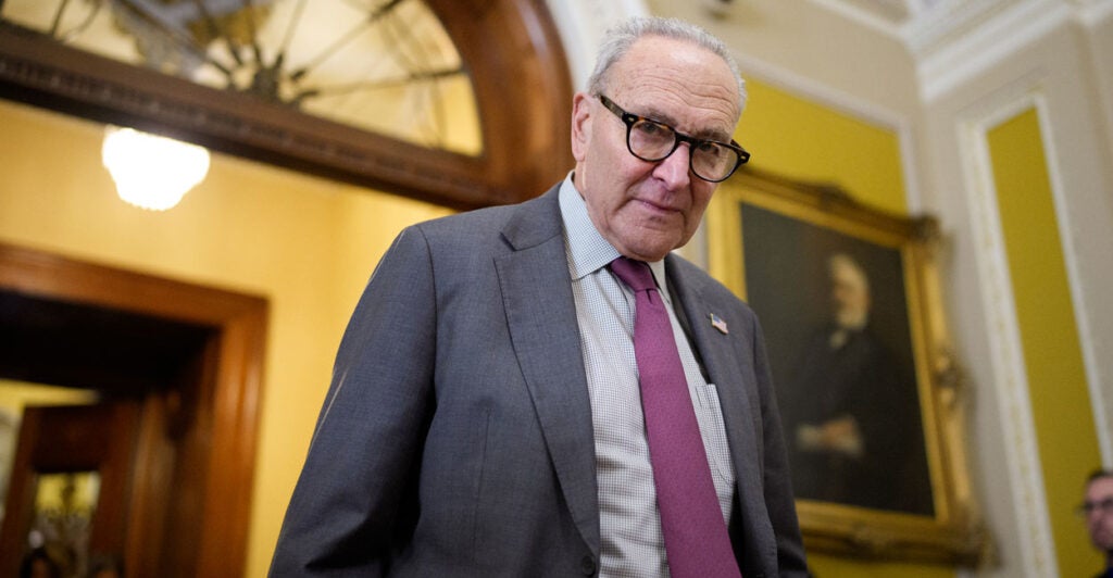 Senate Minority Leader Chuck Schumer, D-N.Y., walks out of a room at the Capitol.