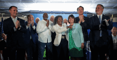 Virginia Republican candidates—Jason Miyares (left), Winsome Earle-Sears (center), and John Reid (right), along with Gov. Glenn Youngkin (second from right)—gather before supporters at a campaign event on July 1 in Vienna, Va. (Kayla Bartkowski/Getty Images)