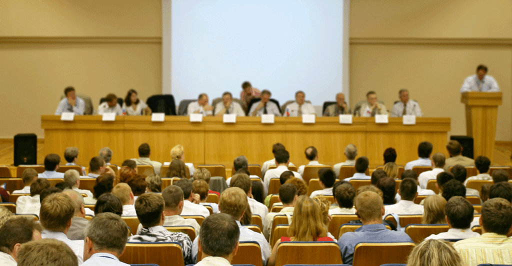 A school board meeting in a large auditorium