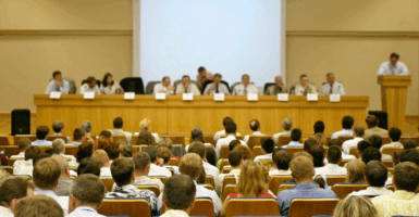 A school board meeting in a large auditorium