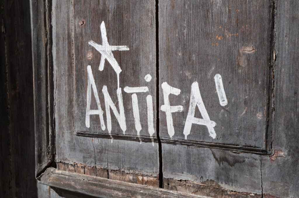 Graffiti reading ''Antifa'' is painted in white on the wooden door of a university building in Bari, Italy, on Sept. 19.