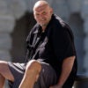 Wearing shorts, Sen. John Fetterman, D-Pa., sits on the Capitol Steps.