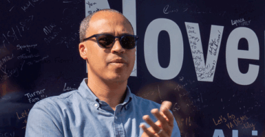 Jay Jones in Fairfax, VA on June 26 at a campaign bus tour stop clapping with sunglasses on in a blue shirt