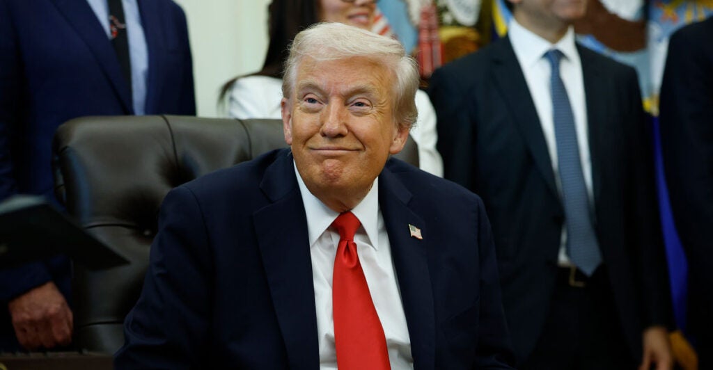 President Donald Trump listens as administration officials speak during an event in the Oval Office.