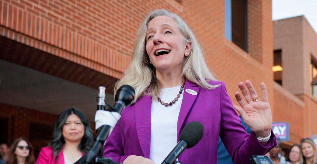 Abigail Spanberger wearing blue and white with an "I voted" sticker
