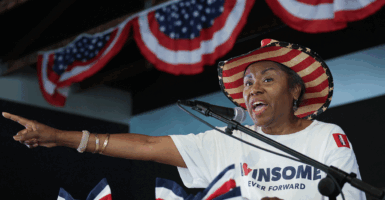 Winsome Earle-Sears on stage at a rally wearing an American flag cowboy hat.