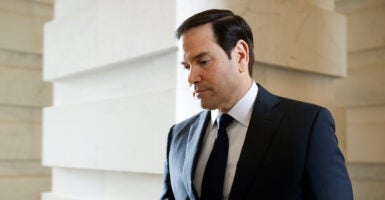 Marco Rubio, head down, walking.