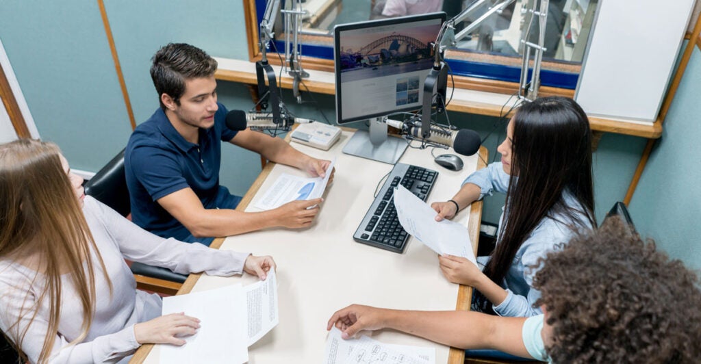 Four journalism students broadcasting from the university's radio station
