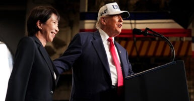 President Trump in a white USA hat with blue lettering, stands with Japanese Prime Minister Sanae Takaichi.