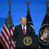 With U.S. flags as a backdrop, President Donald Trump speaks at the American Business Forum in Miami on Wednesday.