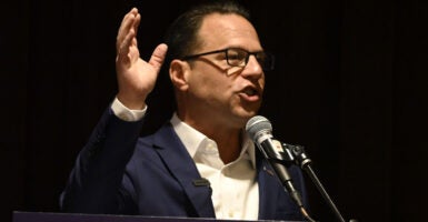 Democrat Pennsylvania Gov. Josh Shapiro at a microphone and gesturing with his right arm