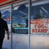 A “We Accept Food Stamps” sign hangs in the window of a grocery store on Friday in Miami, Florida. The food stamp program is now known as the Supplemental Nutrition Assistance Program.