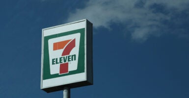 A 7 Eleven sign stands out against a blue sky.