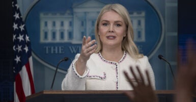 Karoline Leavitt points to reporter from White House podium.
