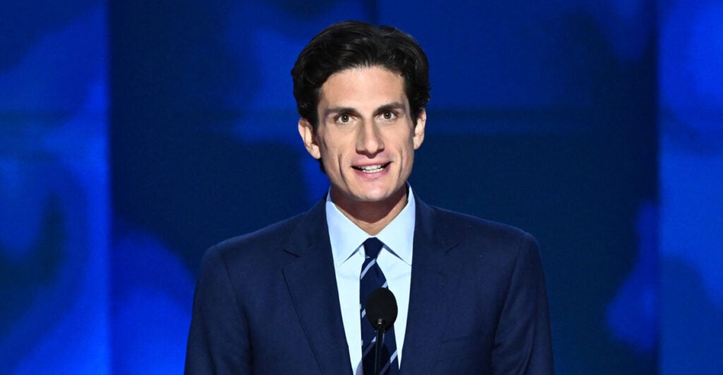 Jack Schlossberg in a blue suit against a blue background.