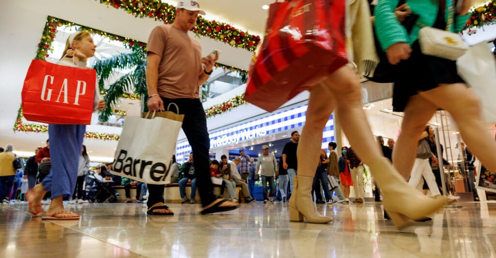 Shoppers walk through a mall.