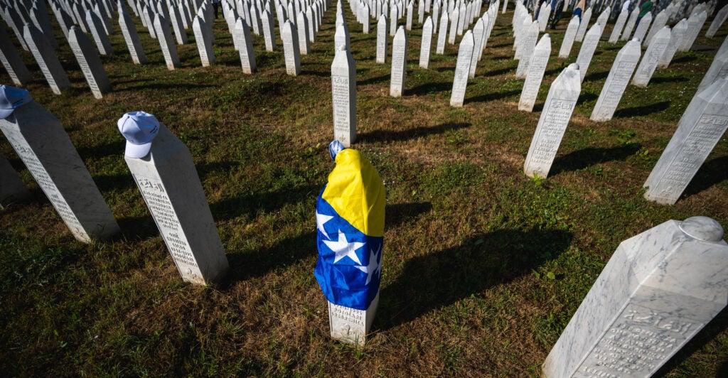 A gravestone is covered with the flag of Bosnia and Herzegovina.