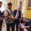 U.S. Sen. John Fetterman (D-PA) sits on a couch speaking to reporters outside the Senate Chamber at the U.S. Capitol.