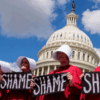 Protesters dressed as handmaids from The Handmaid's Tale stop in front of the Dome of the U.S. Capitol Building on Sep. 2, 2025
