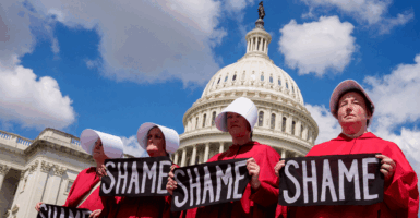 Protesters dressed as handmaids from The Handmaid's Tale stop in front of the Dome of the U.S. Capitol Building on Sep. 2, 2025