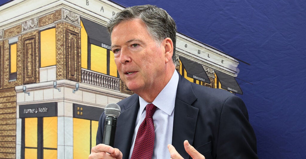 James Comey in a suit speaks with a microphone. A judge heard arguments for dismissing the prosecutor who brought charges against James Comey and Letitia James.
