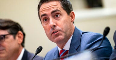 Ohio Secretary of State Frank LaRose speaks at a microphone from his seat.