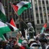 Pro-Palestine protesters hold a flag. Princeton University is offering a course on gender and genocide in Gaza featuring a professor who denied that Hamas raped Israelis on Oct. 7.