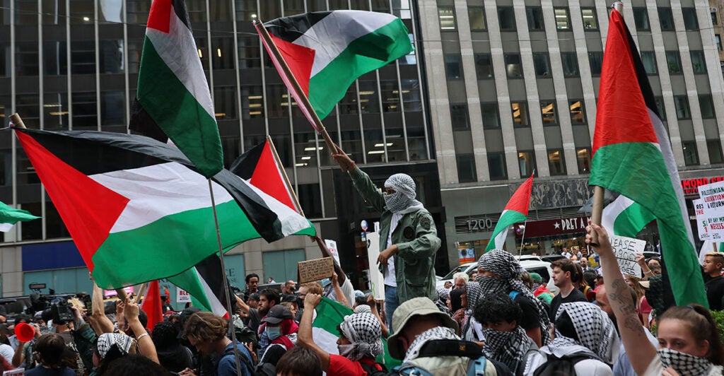 Pro-Palestine protesters hold a flag. Princeton University is offering a course on gender and genocide in Gaza featuring a professor who denied that Hamas raped Israelis on Oct. 7.