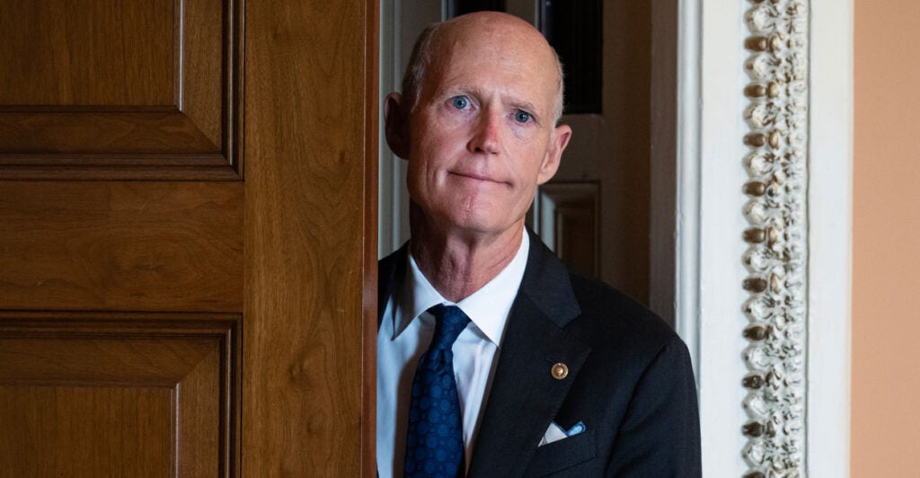 Senator Rick Scott of Florida exits a room in the United States Capitol.