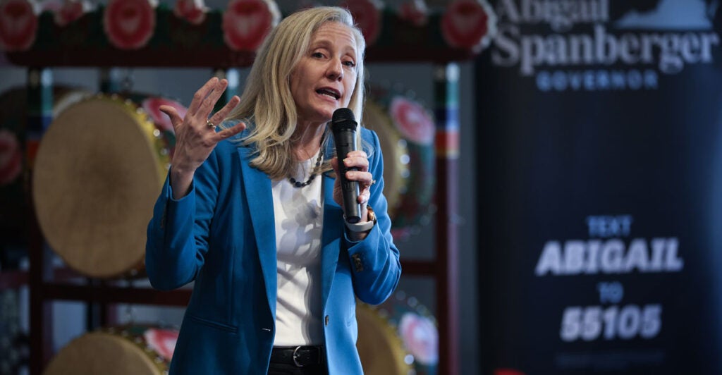 Abigail Spanberger holds a microphone as she speaks at a campaign event.