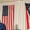 Ohio GOP Chairman Alex Triantafilou stands at a podium with the American and Ohio flags behind him.