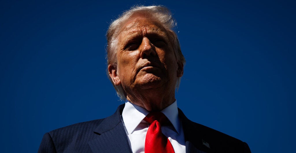 Close up of Donald Trump against a blue sky.