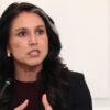 Tulsi Gabbard speaks at an event and gestures with both of her hands in front of her.