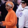 Ilmar Omar stands in a hallway with a cell phone in her left hand.