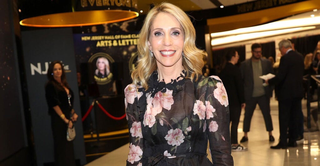 Dan Bash stands and poses in front of the entrance of a theater.