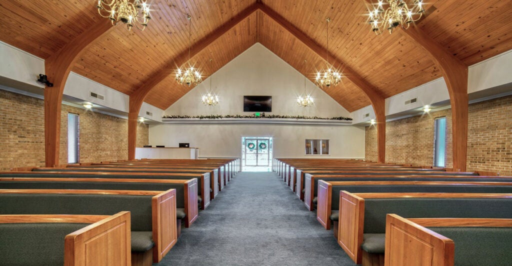 The inside of a church is shown with a viewpoint from the back looking forward.