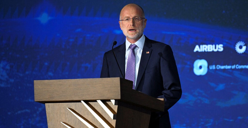FCC Chair Brendan Carr speaks in front of a blue background.