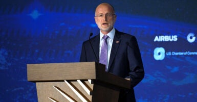 FCC Chair Brendan Carr speaks in front of a blue background.