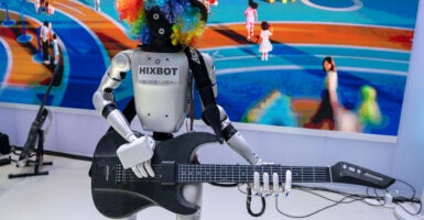 A silver Mexbot Robot in rainbow-colored wig holds a black guitar.