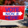 People walk past a vote-here sign advertising the Virginia Senate elections taking place on November 8, in Alexandria, Virginia, November 5, 2011. Virginia's state Senate elections next week are shaping up as an early signal for President Barack Obama ahead of national elections next year. REUTERS/Molly Riley (UNITED STATES - Tags: POLITICS ELECTIONS)