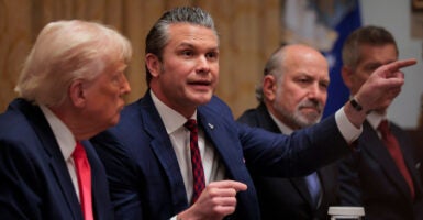 Pete Hegseth, with Donald Trump at his right and Howard Lutnick to his left points during a cabinet meeting.