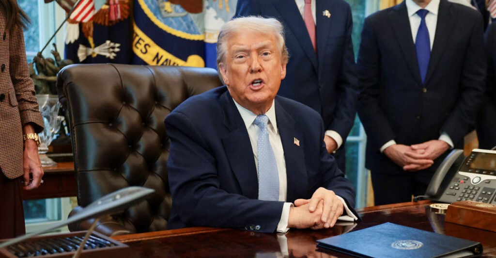 President Trump speaks to reporters from his desk in the Oval Office.