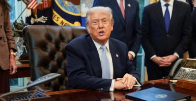 President Trump speaks to reporters from his desk in the Oval Office.