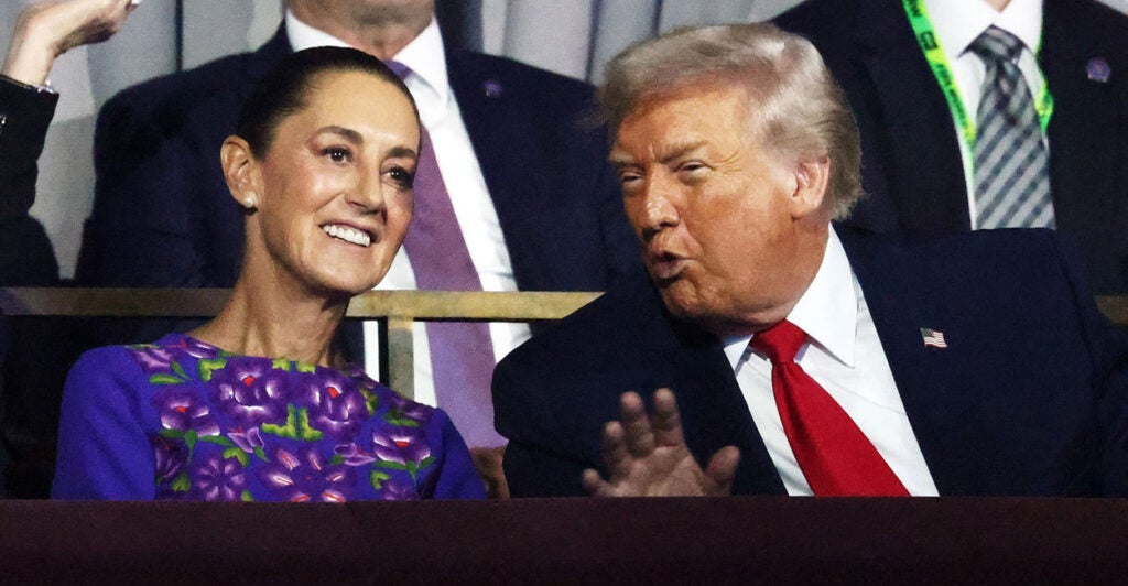 President Trump leans over to talk to Mexican President Claudia Sheinbaum.