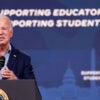 Then-President Joe Biden behind a podium speaks in front of a blue backdrop with white lettering reading "Supporting Education Supporting Students."