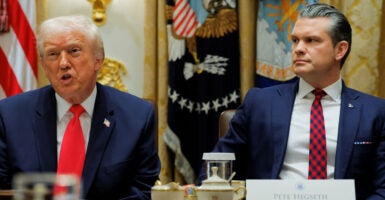 Donald Trump and Pete Hegseth sit at a Cabinet meeting.