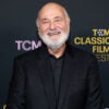 A smiling Rob Reiner in black in front of a TCM Classic Film Festival backdrop