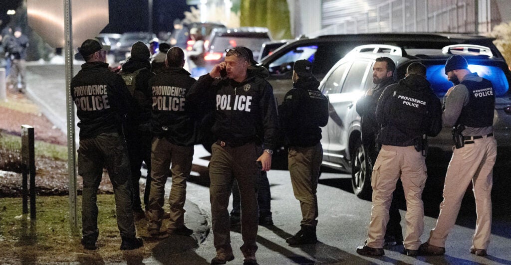 Law enforcement gather on street.